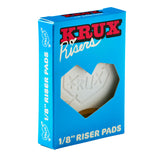 Blue Krux 1/8in Riser Pads box with a heart-shaped window, showcasing a white riser pad.