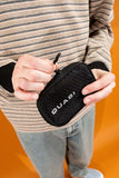 Person holding a black Quasi Skateboards Crypto Wallet with a textured pattern and zipper