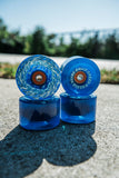 Four translucent blue Slime Balls SB Ice Light Ups Wheels stacked on outdoor concrete.