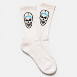 Pair of 100% Baker white crew socks featuring a black skull design with 'BAKER' text in blue, laid flat.